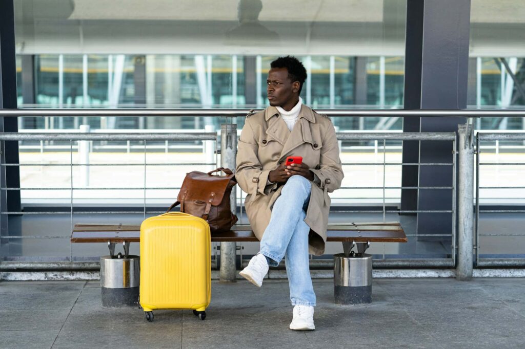 Airport passenger with luggage waiting for a pre-booked transfer